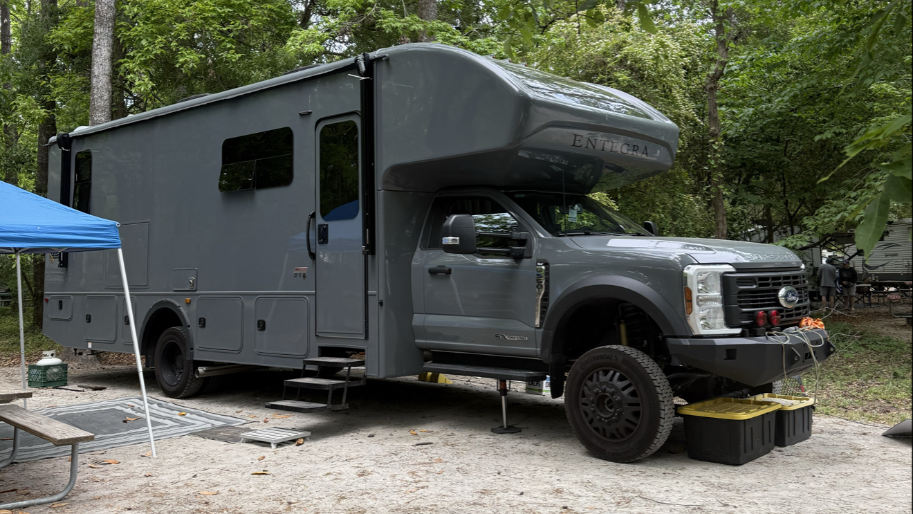 Grey camper on a wooded campsite